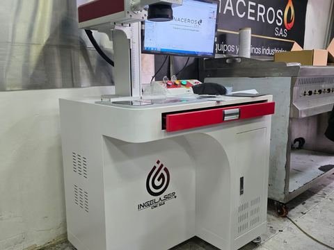 Marcadora láser de sobremesa instalada en el taller de un cliente (Inaceros S.A.S): mueble bajo con logo Ingelaser.