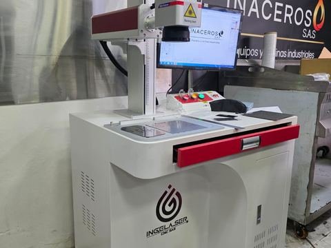 La misma marcadora del taller de Inaceros, en plano algo más abierto y frontal: se ve completa la mesa de trabajo con la pieza.