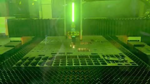 Corte de lámina gruesa visto tras el vidrio verde de protección, pantalla del control con los parámetros del programa.