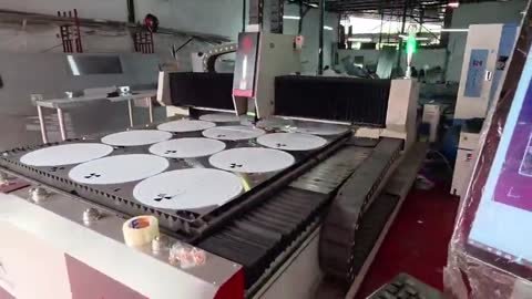 Cortadora de lámina SP-3015A con mesa única abierta cargada de tapas circulares grandes ya cortadas.