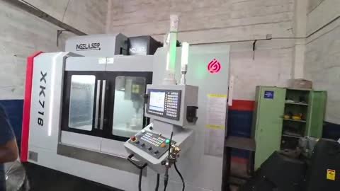 Fresadora CNC de columna con cabina cerrada, rotulada XK716 y con la marca INGELASER en la parte superior.