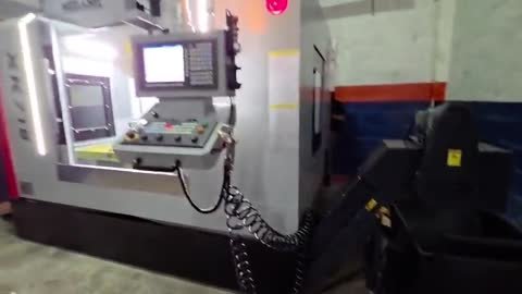 Fresadora CNC de columna rotulada XK716 y marcada Ingelaser, en una nave con luz baja: paneo desde la esquina frontal.