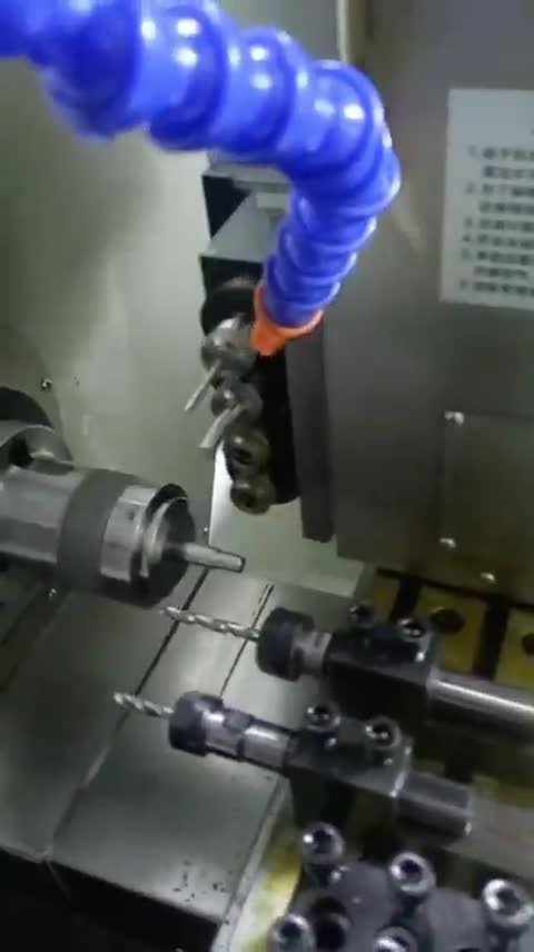Mismo torno CNC compacto: el husillo con portabrocas gira y la broca avanza taladrando la pieza.
