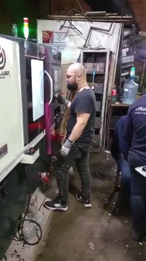 Torno CNC de cabina cerrada mecanizando con inundación de refrigerante sobre el bloque de herramientas gang.
